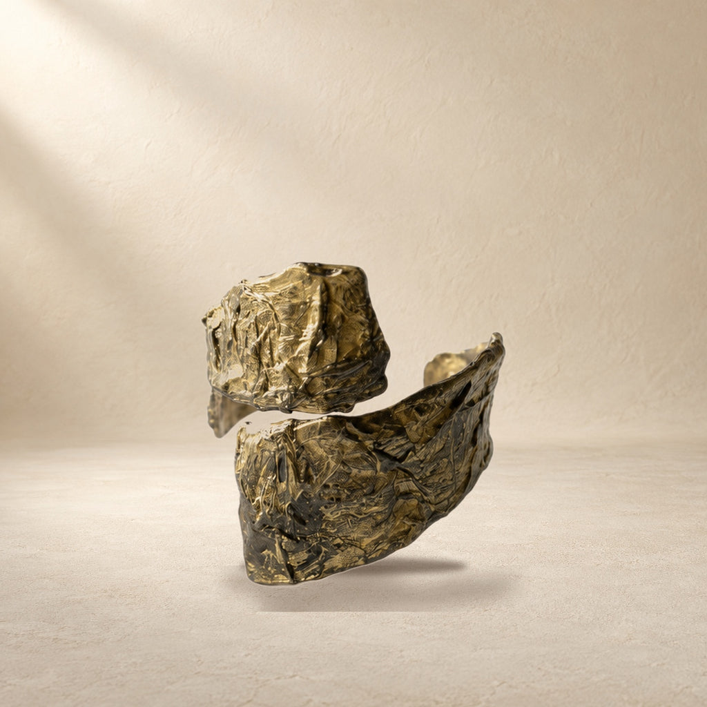 Divided Current bracelet resting on a warm cream surface