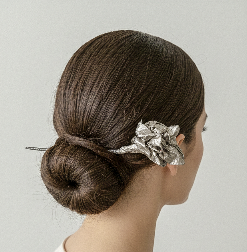 Crushed Bloom silver sculptural paper hairpin worn in a low dark hair bun