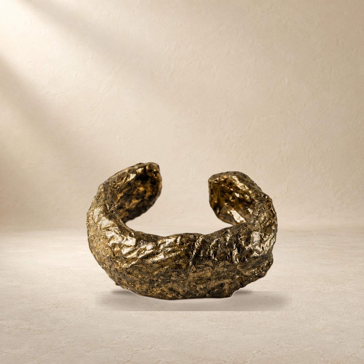 Gilded Seam bracelet resting on a warm cream surface
