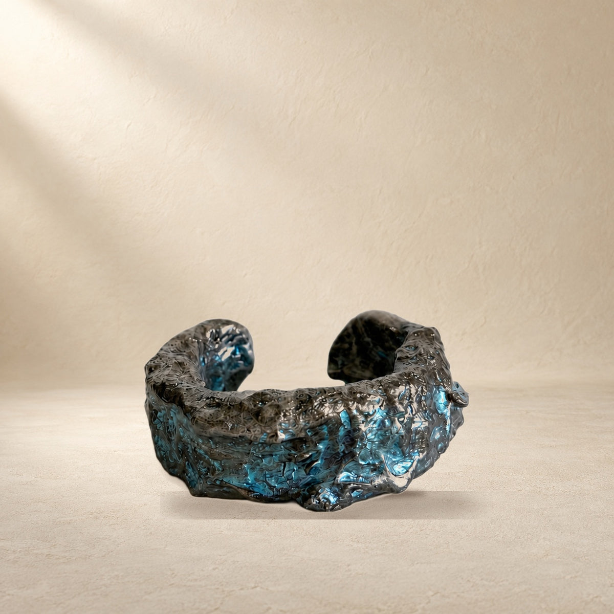 Tidal Fault bracelet resting on a warm cream surface