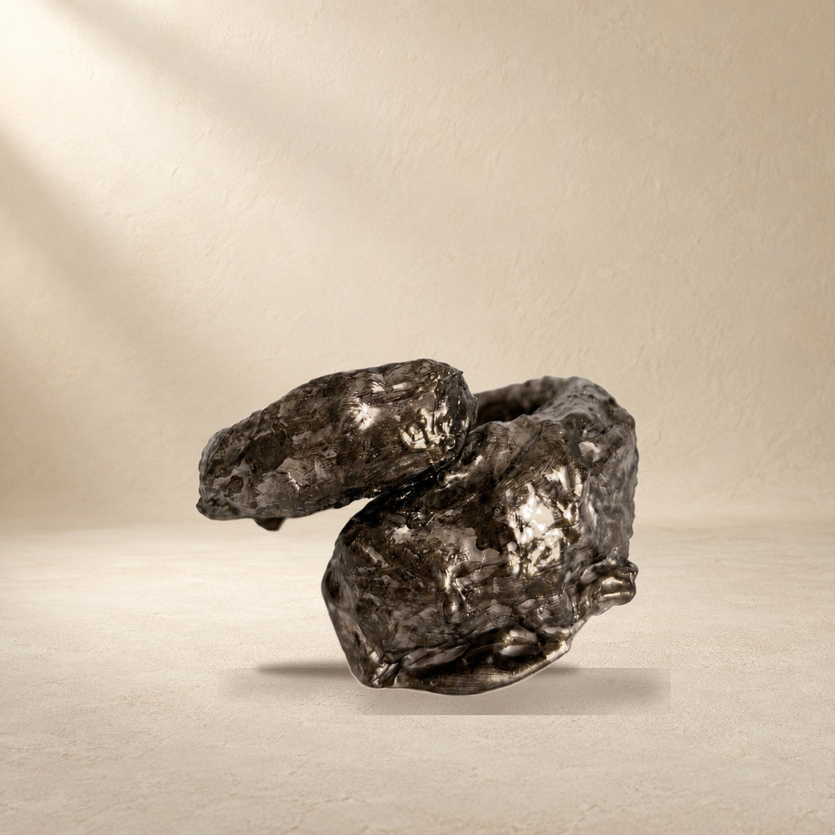 Held Fracture bracelet resting on a warm cream surface