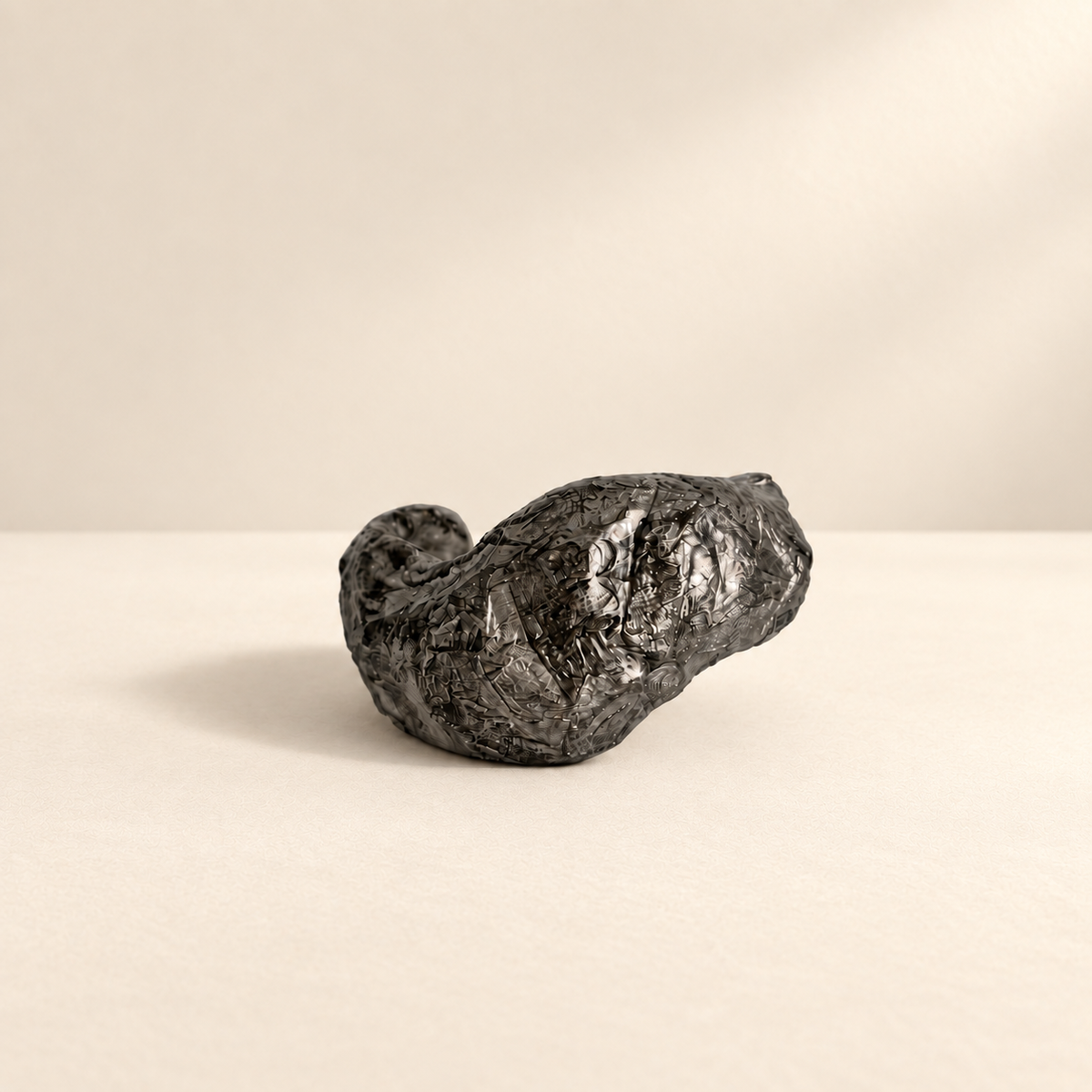 Folded Current — Sculptural Paper Cuff Bracelet resting on a warm ivory studio surface with a natural grounding shadow — Niksa Design