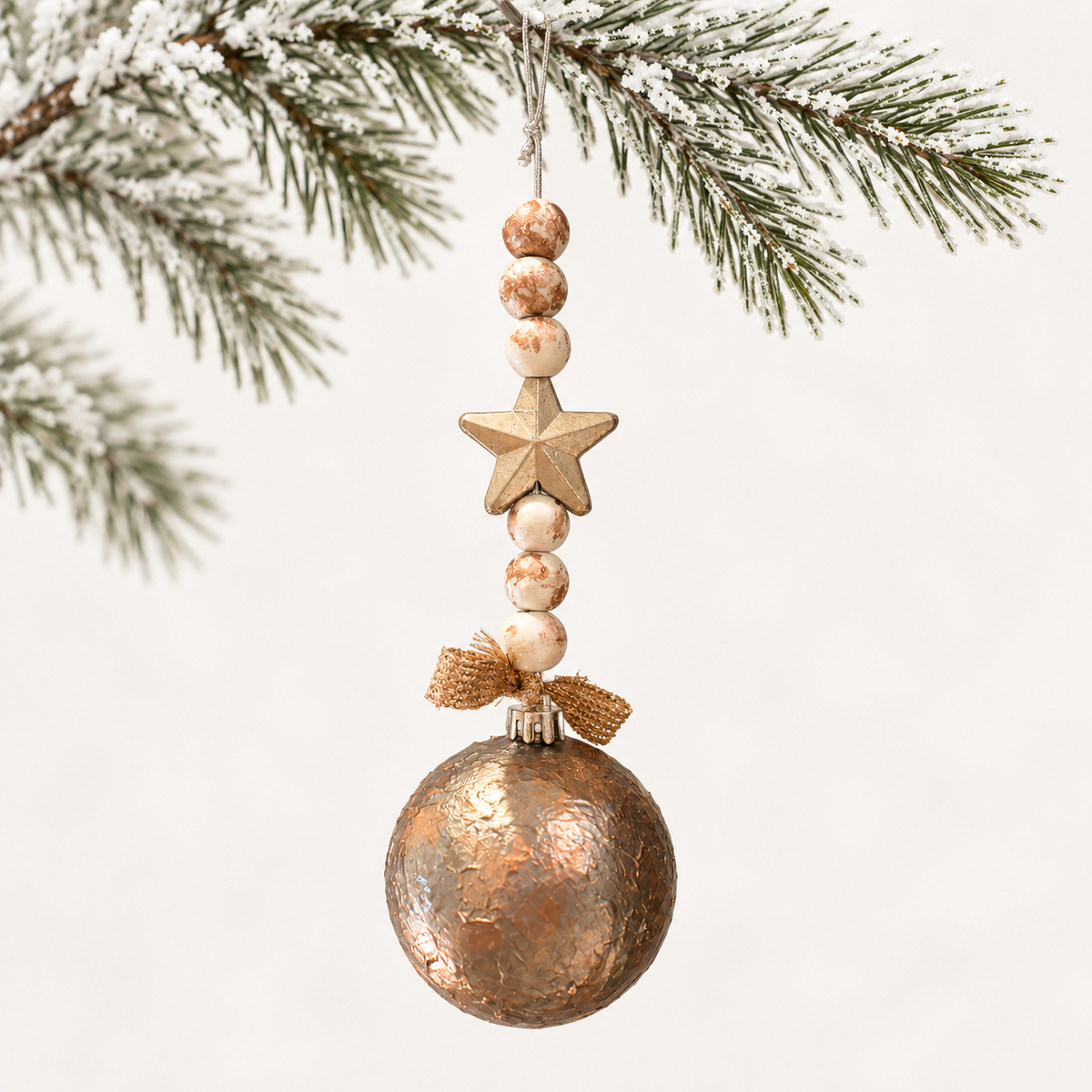 Textured bronze-toned ball with a gold-toned star, marbled ivory beads and a gold-toned ribbon.