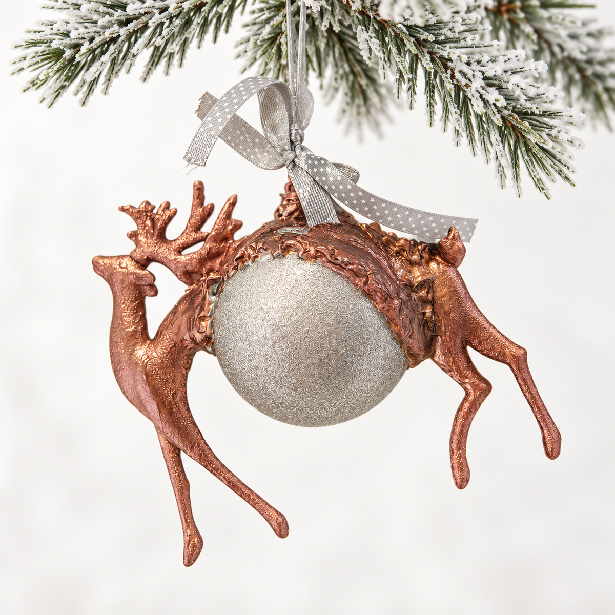 Copper-toned deer form surrounding a textured silver-toned sphere, finished with a star-patterned ribbon.