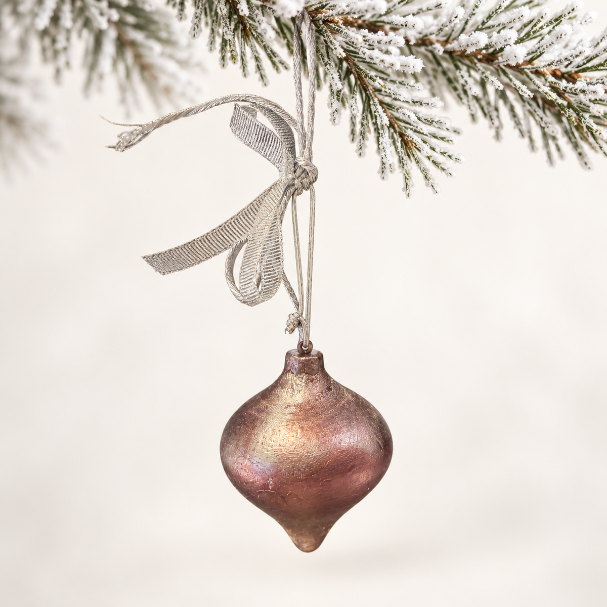 Rounded pointed drop with rose and bronze tones and a silver ribbon.
