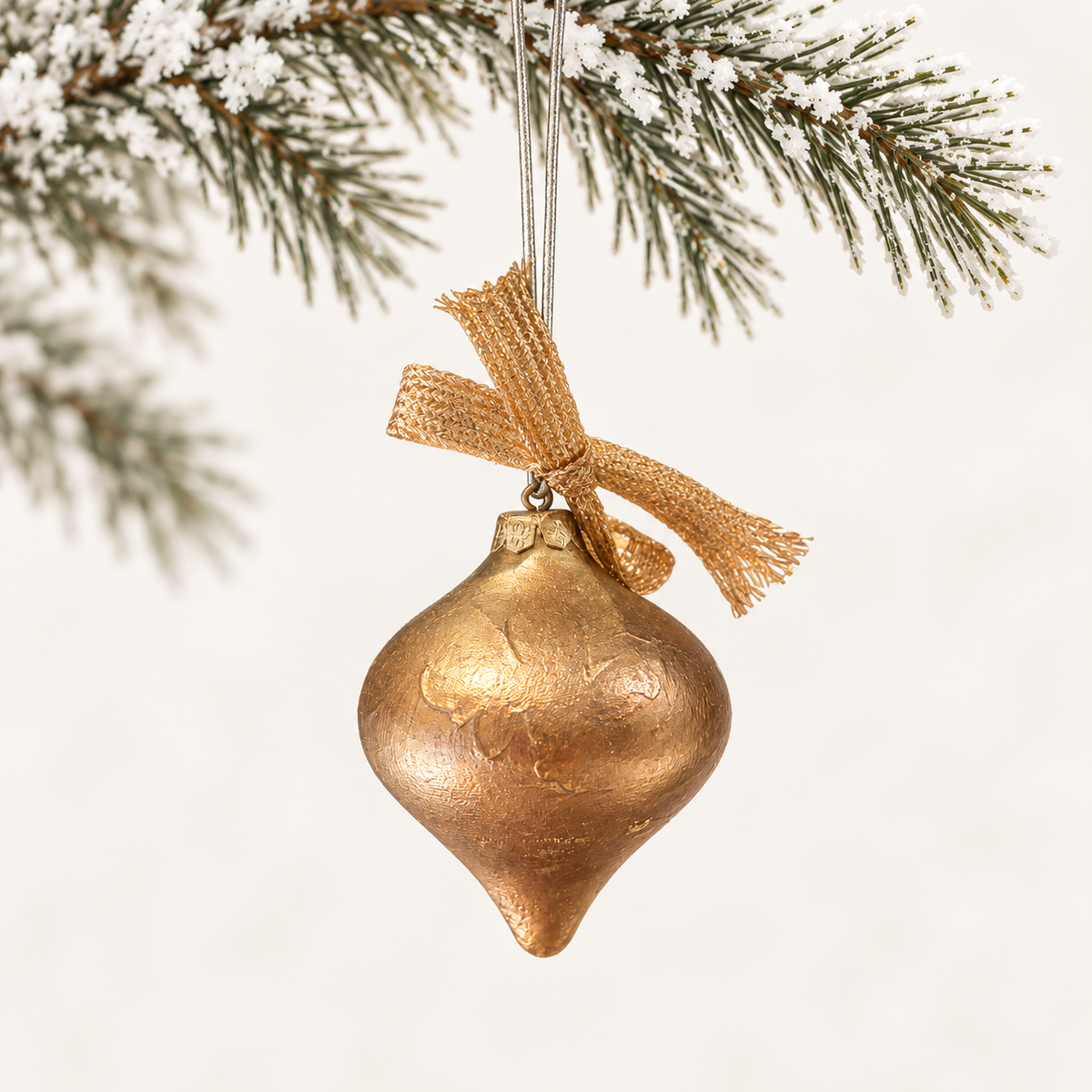 Textured gold-toned pointed drop with a gold-toned ribbon.