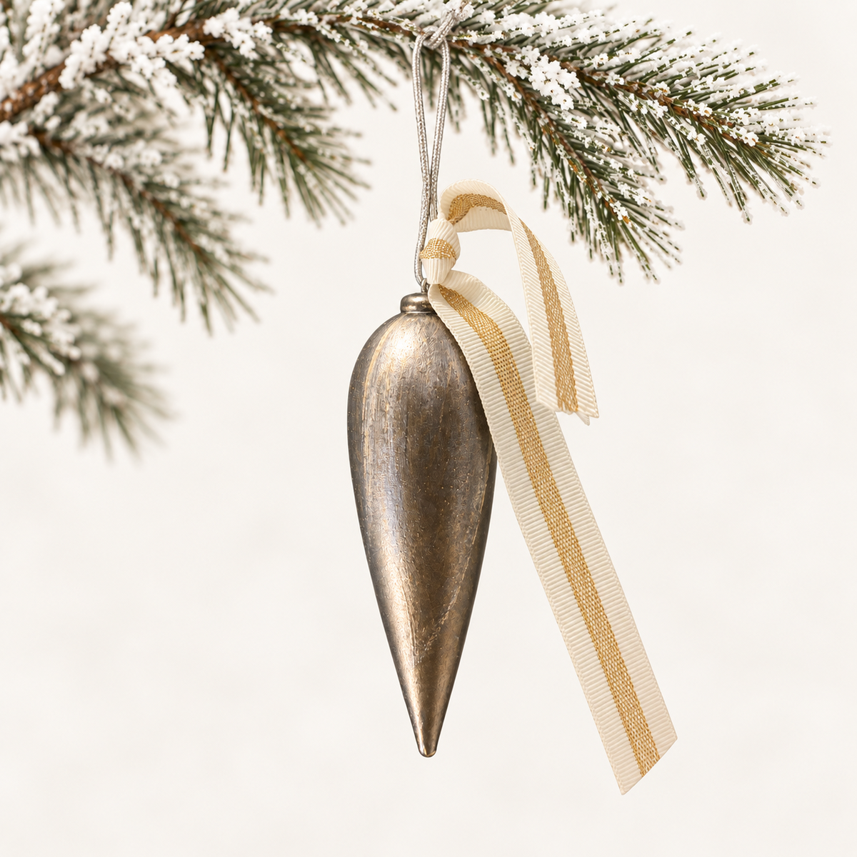 Long tapered finial in antique bronze tones with a cream and gold-striped ribbon.