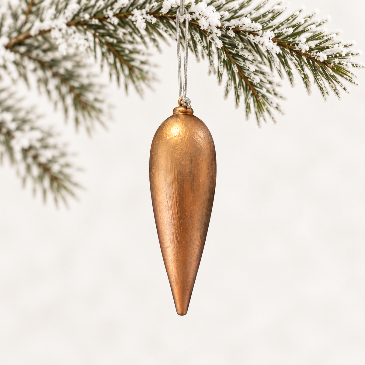 Long tapered finial with a textured copper-toned finish and a silver hanging cord.