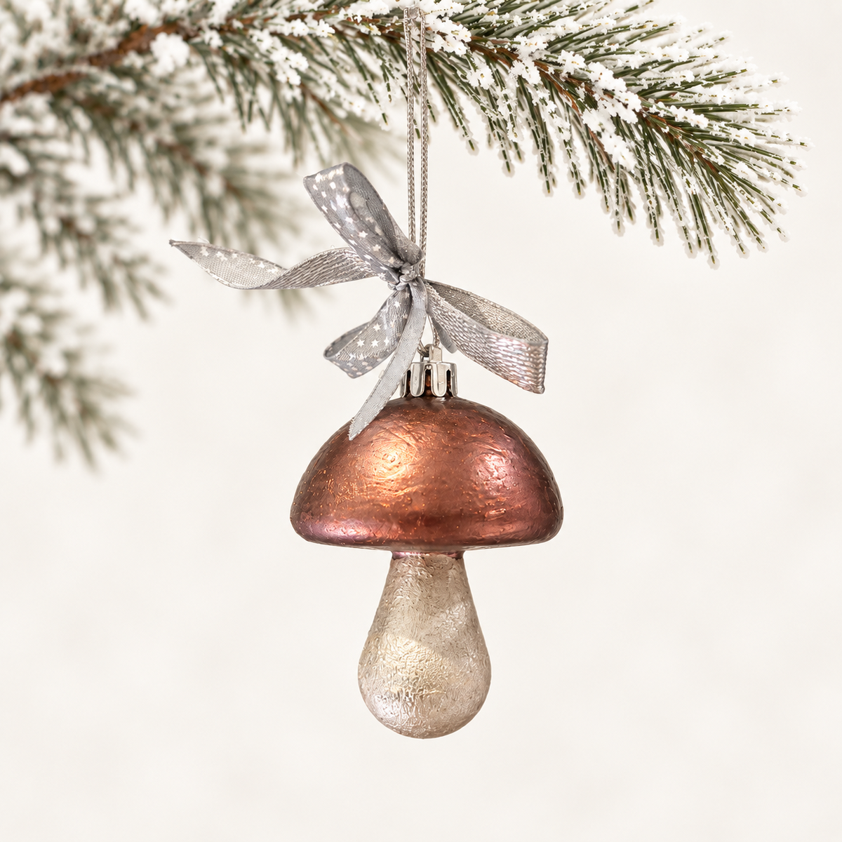 Mushroom form with a copper-toned cap, a silver-toned stem and a silver star-patterned ribbon.