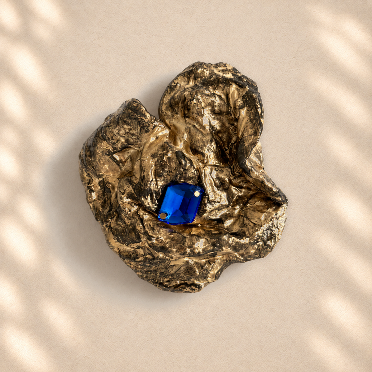 Cobalt Cradle brooch on warm cream background