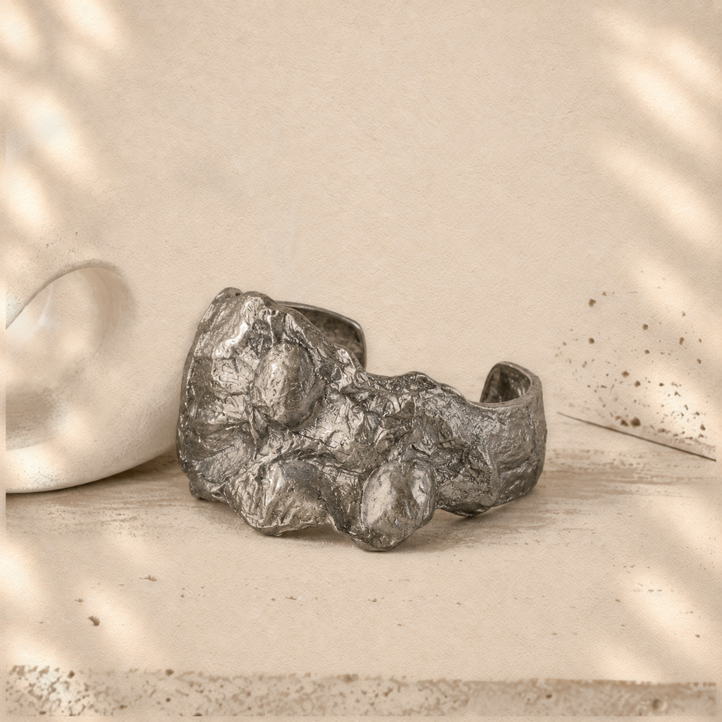 Silver Fault — Sculptural Paper Cuff Bracelet on warm cream background