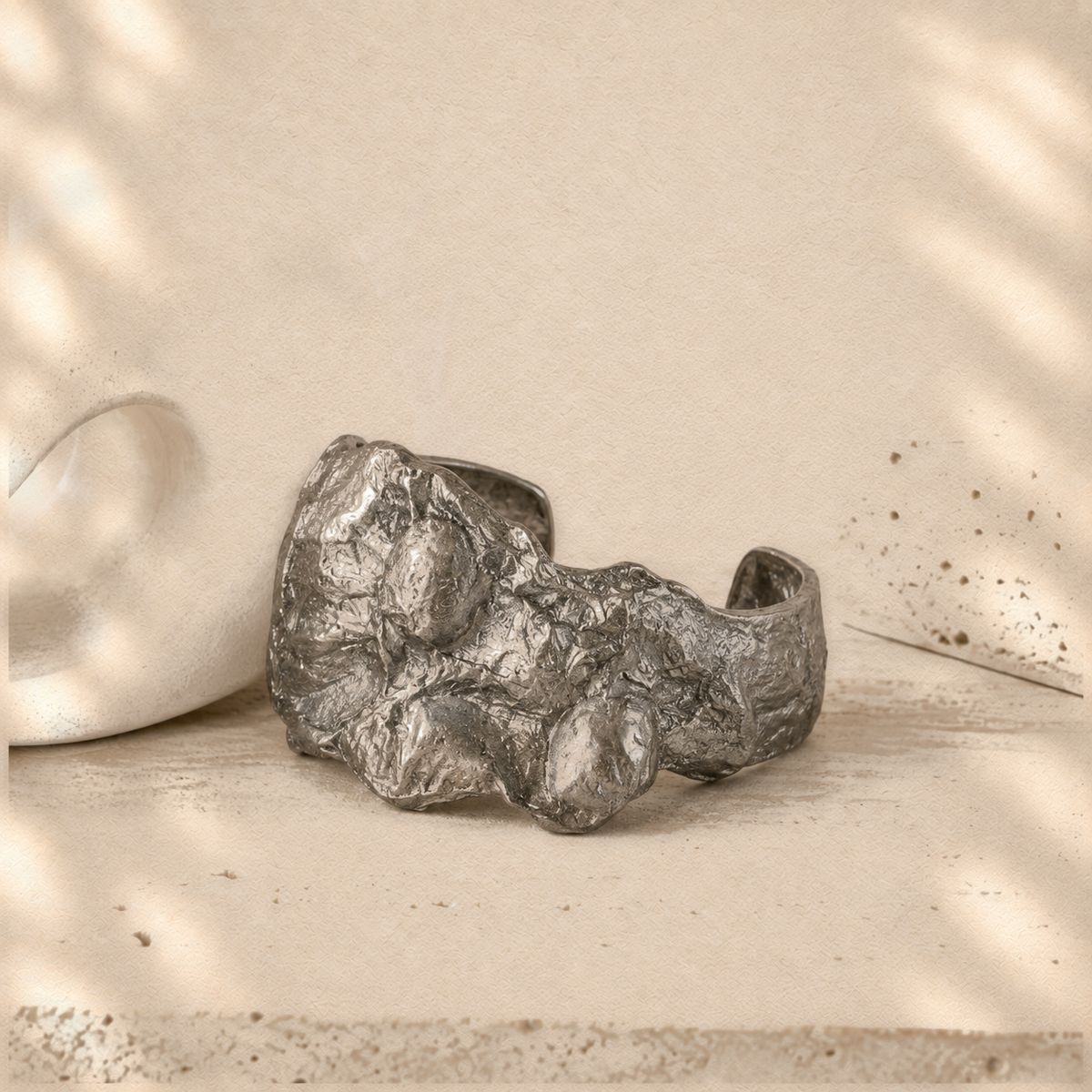 Silver Fault — Sculptural Paper Cuff Bracelet on warm cream background