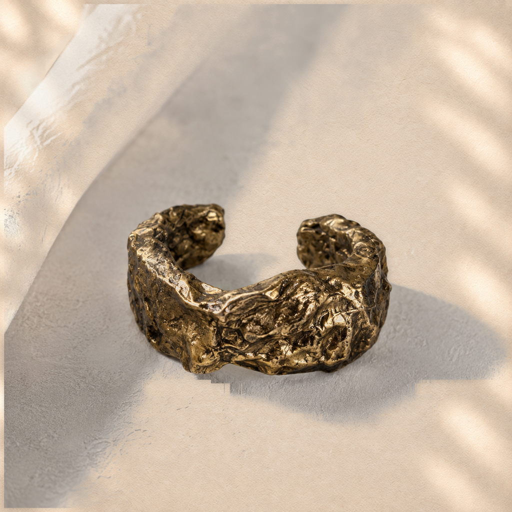 Gilded Swell — Sculptural Paper Cuff Bracelet on warm cream background