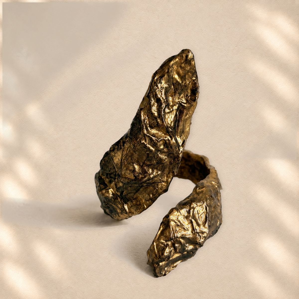 Gilded Reach — Sculptural Paper Cuff Bracelet on warm cream background
