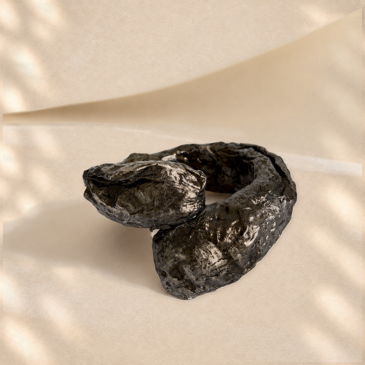Obsidian Fold — Sculptural Paper Cuff Bracelet on warm cream background