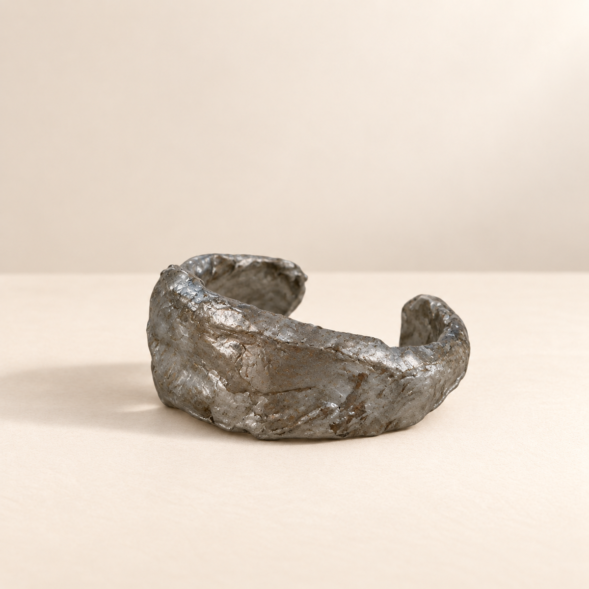 Silver Contour I handmade paper cuff resting on ivory surface