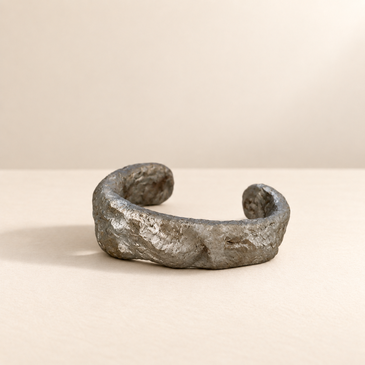 Silver Contour II handmade paper cuff resting on ivory surface