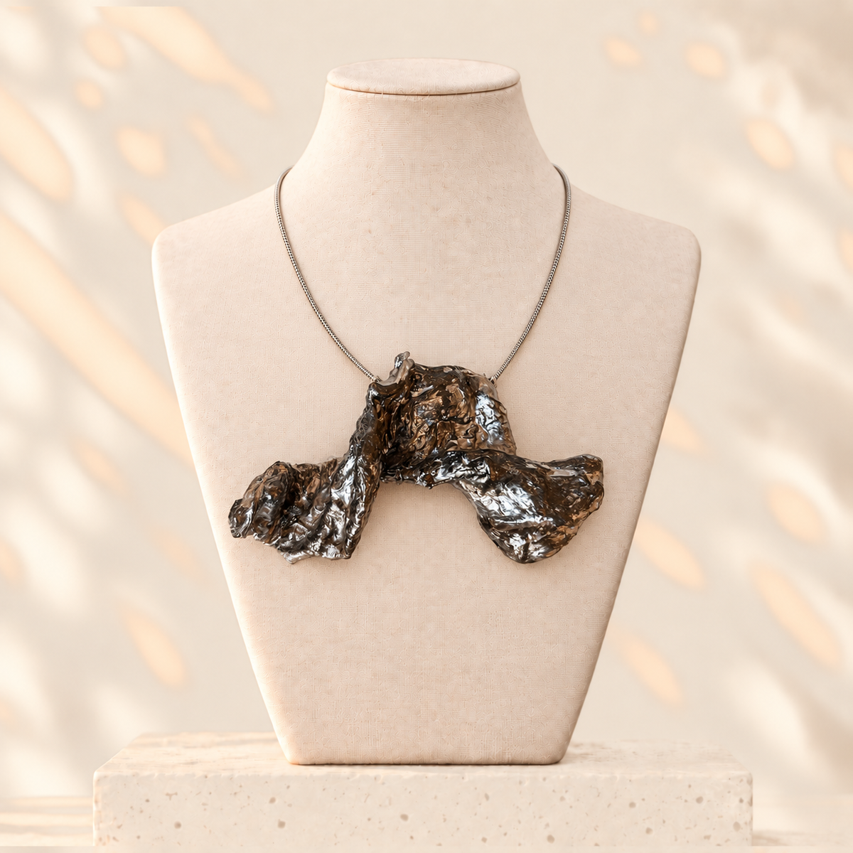 Silver Reverberation - upright pendant with high central fold and two lower outer lobes, on ivory mannequin