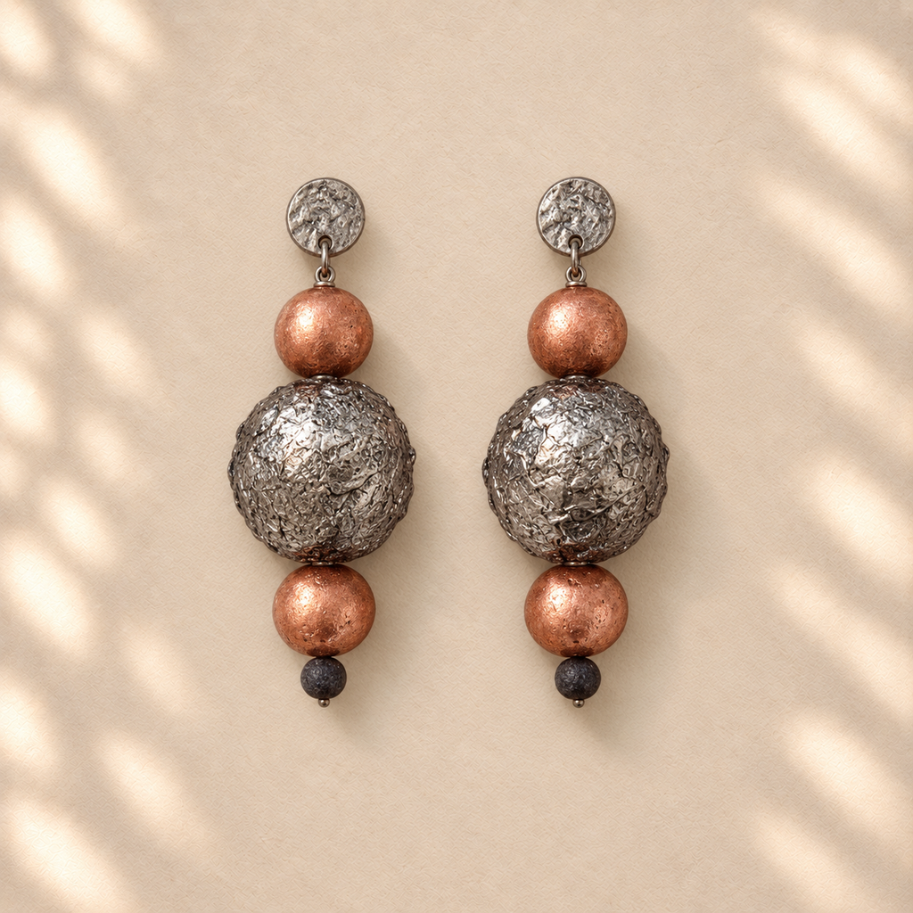 Tension in Balance Orange variant - upright copper and silver sphere earrings on cream background