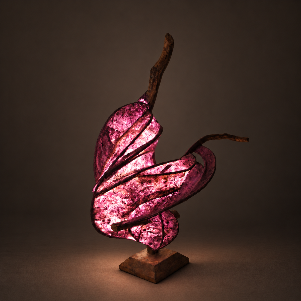 Violet Ember sculptural lamp illuminated against warm charcoal