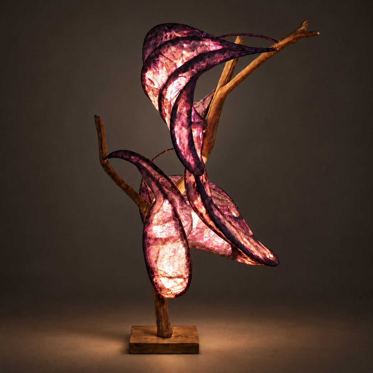 Wild Tulip sculptural lamp illuminated against warm charcoal